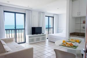 een woonkamer met een kamer met een bed en een televisie bij Classic Flat Residence Service ap.902 in Fortaleza