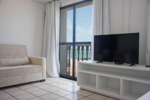 een woonkamer met een flatscreen-tv en een bank bij Classic Flat Residence Service ap.902 in Fortaleza