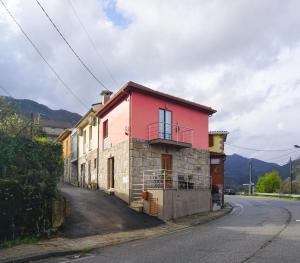 ein rotes und weißes Haus am Straßenrand in der Unterkunft Geyra - Gerês Nature Home in Geres