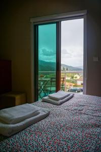 two beds in a room with a large window at Geyra - Gerês Nature Home in Geres
