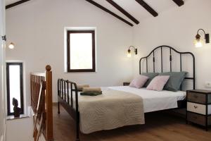 a bedroom with a bed with pink and blue pillows at Studio apartman Kendi in Sutivan