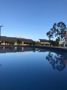 a swimming pool with a reflection of a house at GRAVATÁ WINTERVILLE FLAT 707 in Gravatá