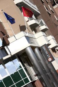 two flags flying in front of a building at At Home Appart Hotel in Toulouse