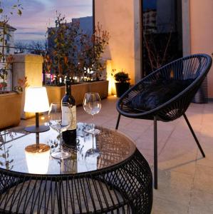 a table and chairs with a bottle of wine and glasses at La Terrazza 62 in Bergamo