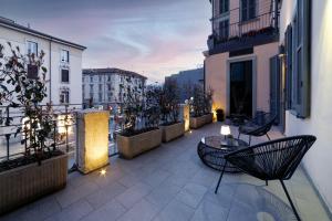 - un balcon avec des chaises et une table dans un bâtiment dans l'établissement La Terrazza 62, à Bergame