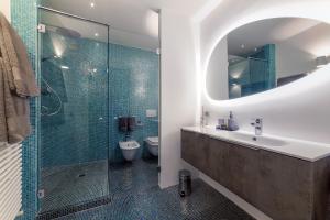 La salle de bains est pourvue d'un lavabo et d'une douche en verre. dans l'établissement La Terrazza 62, à Bergame