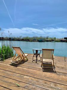 two chairs and a table on a dock next to the water at Zen House for 2 in Ulcinj