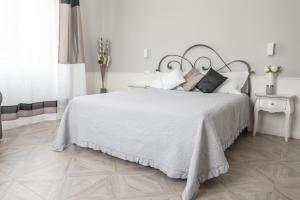biała sypialnia z dużym łóżkiem z białą pościelą i poduszkami w obiekcie Golfo dei Poeti Retreat w mieście La Spezia