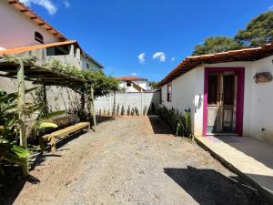 eine Auffahrt zu einem Haus mit einer lila Tür in der Unterkunft Aconchego de Tiradentes in Tiradentes