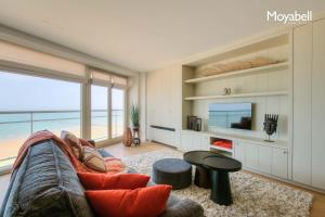 a living room with a couch and a view of the ocean at 7e verdiep Appartement met zeezicht in Knokke voor 6 personen in Knokke-Heist