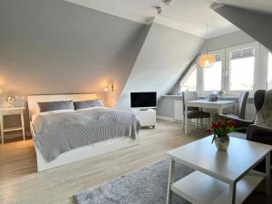 a bedroom with a bed and a living room at Haus Eberhardt Appartement 2 in Tinnum