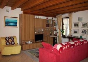 アオスタにあるAppartamento da Paolo Love Aostaのリビングルーム(赤いソファ、椅子付)