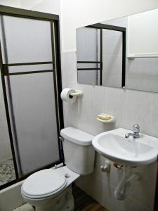 a bathroom with a toilet and a sink at Casa Blanca Puerto López in Puerto López