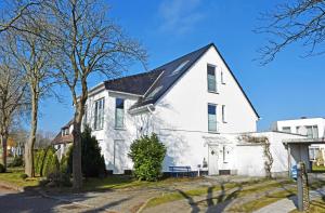 ein weißes Haus mit einem schwarzen Dach in der Unterkunft schöne Ferienwohnungen in Dranske auf dem Windland in Dranske