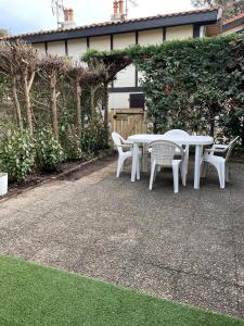 einen weißen Tisch und Stühle auf einer Terrasse in der Unterkunft Maison à 300m de la plage, quartier calme in Mimizan
