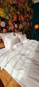 a large white bed with a floral wall at Paradiso Perduto Private Apartment by Weinkeller in Sibiu