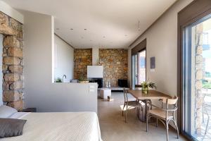 a bedroom with a bed and a table and a kitchen at Euphoria Suites in Avía
