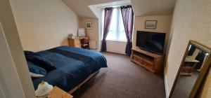 a bedroom with a bed and a flat screen tv at Harbour bridge, Camps bar in Wick