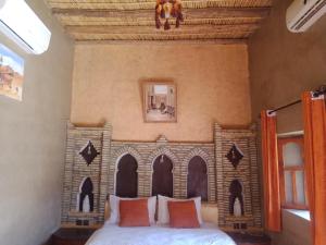 a bedroom with a bed with a castle headboard at Hotel Riad Le Petit Prince in Merzouga
