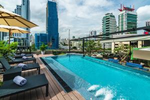 a swimming pool on top of a building with buildings at Tastoria Collection Sukhumvit in Bangkok
