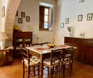 a dining room with a table and chairs and a kitchen at La Casina in Buonconvento