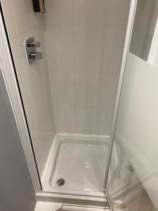 um chuveiro com uma porta de vidro e um chuveiro em The Glen Guest House 1-bedroom guest house with free parking em Fyfield