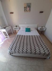 a large bed in a room with two tables at Doukas in Skala Rachoniou