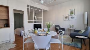 a living room with a white table and chairs at Au 53, sous le chartil in Reims +8 photos