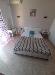 een bed in een kamer met 2 tafels bij Doukas in Skala Rachoniou