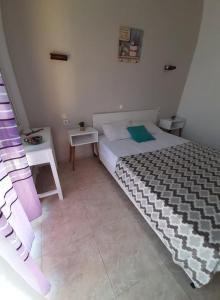 een slaapkamer met een groot bed en een tafel bij Doukas in Skala Rachoniou