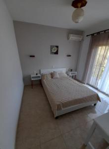 a bedroom with a bed and a clock on the wall at Doukas in Skala Rachoniou