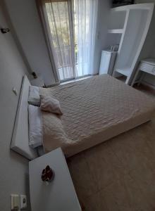 een groot bed in een kamer met een tafel bij Doukas in Skala Rachoniou
