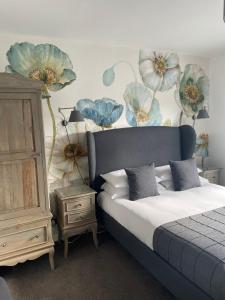 um quarto com uma cama com flores azuis na parede em Falmouth Bay em Falmouth
