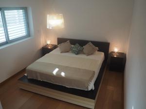 a bedroom with a large bed with two lamps at Olive Ap. in Torreira