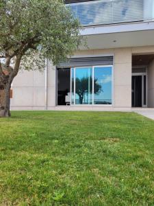 una casa con un árbol delante de un edificio en Olive Ap. en Torreira