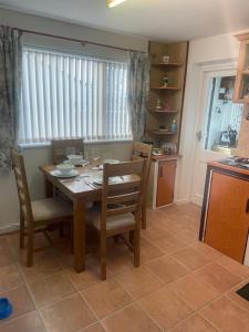 a dining room with a table and chairs and a kitchen at Trudora in Tintagel
