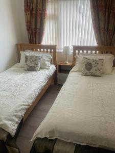 1 dormitorio con 2 camas y ventana en Trudora en Tintagel