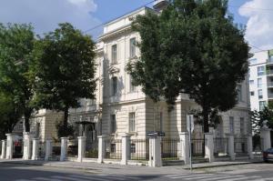 a white building with a fence in front of it at Vienna Suites in Vienna