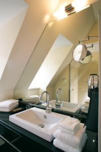 W łazience znajduje się umywalka i lustro. w obiekcie Schiefer Suite Hotel & Apartments w mieście Goslar