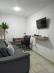 a living room with a couch and a desk and a television at Luxury Department Tlaquepaque in Guadalajara