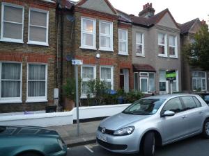 a silver car parked in a parking lot in front of houses at Boundary Road, 1 Bedroom & 2 Bedroom Flats in London