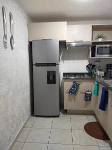 eine Küche mit einem weißen Kühlschrank in der Ecke in der Unterkunft Luxury Department Tlaquepaque in Guadalajara