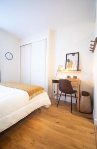 a bedroom with a bed and a desk and a chair at Charmant 2 pièces in Poissy