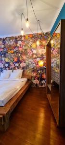 a bedroom with a mural of flowers on the wall at Paradiso Perduto Private Apartment by Weinkeller in Sibiu