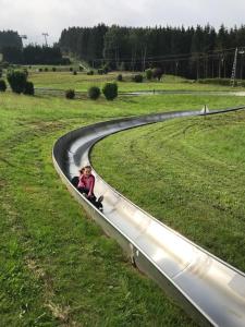 un niño está sentado en una pista en un campo en Hausamaarbach, en Willingen