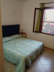 a bedroom with a bed and a window at Monolocale a 200 metri dal mare in Funtana Meiga