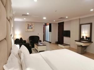 a hotel room with a bed and a living room at Al Jury Serviced Apartments in Al Khobar