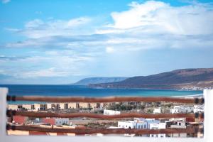 a view of a city with the ocean and buildings at SwellHouse in Tamraght Ouzdar