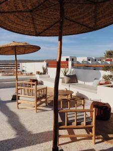a group of tables and chairs with an umbrella at SwellHouse in Tamraght Ouzdar +16 photos