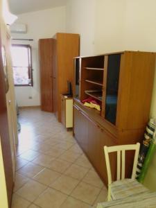 a kitchen with a counter and a cabinet with a tv at Monolocale a 200 metri dal mare in Funtana Meiga